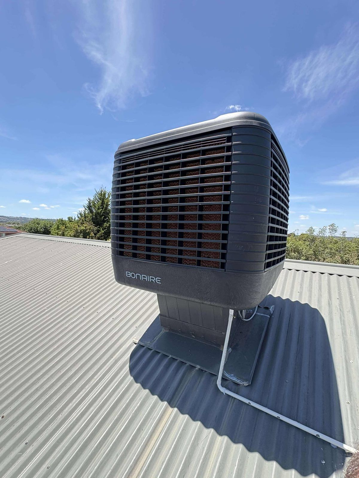 Evaporative cooler on a sunny metal roof