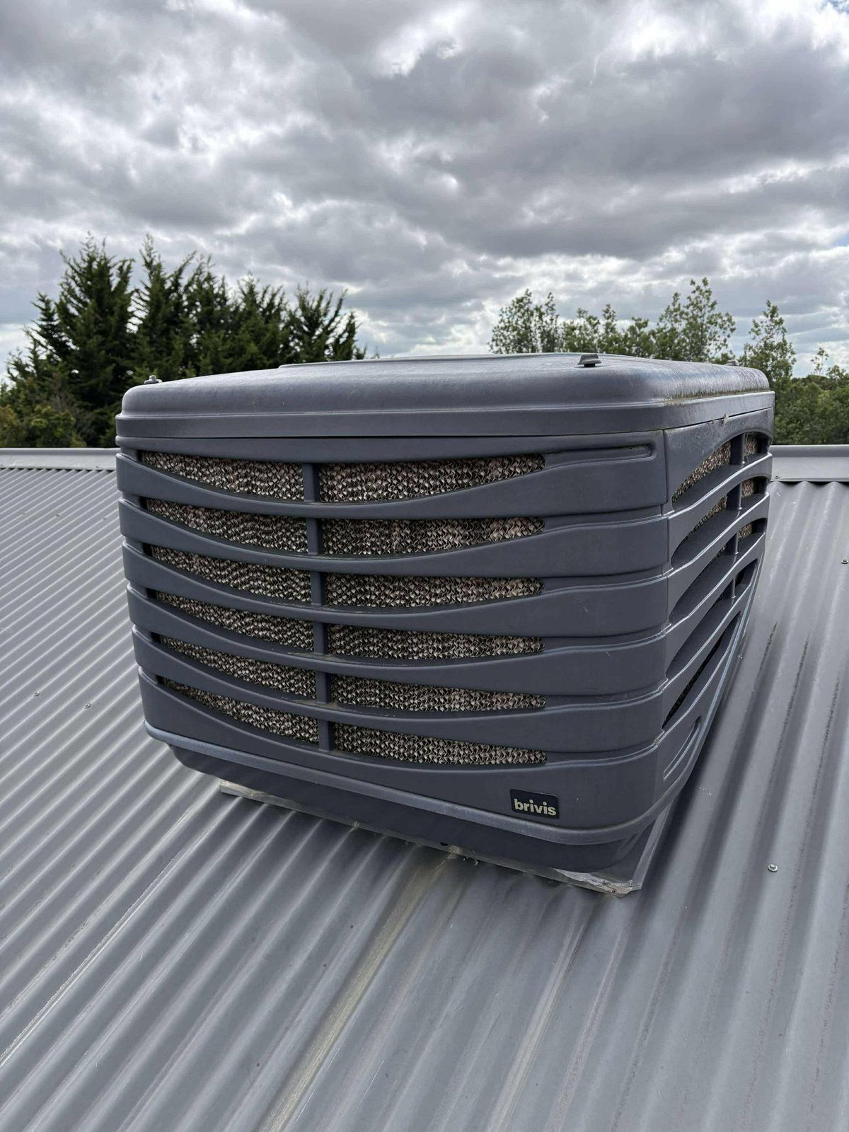 Grey evaporative cooler on a metal roof