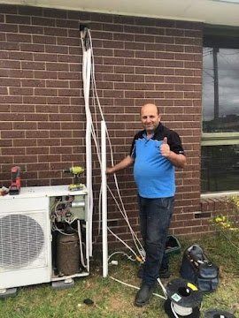 Sam giving a thumbs up next to a split system he is installing